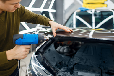 male worker dries car protection film on hood 2023 11 27 05 06 56 utc 1